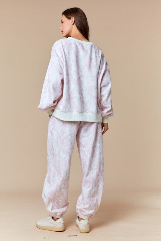 Pantalones deportivos color beige desteñido con estampado de hojas