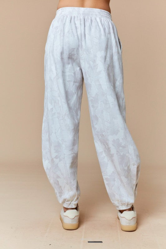 Pantalones deportivos color beige desteñido con estampado de hojas